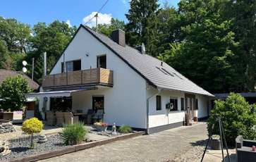 Wohnhaus mit heller Fassade und Holzverkleidung